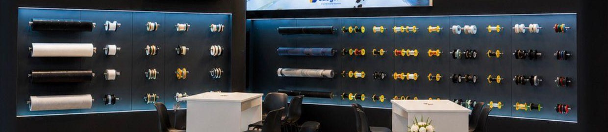 Hinterleuchtete Produktwand mit den eigens gefertigten Metall-Hängesystemen für Textilrollen und Wickelkörper